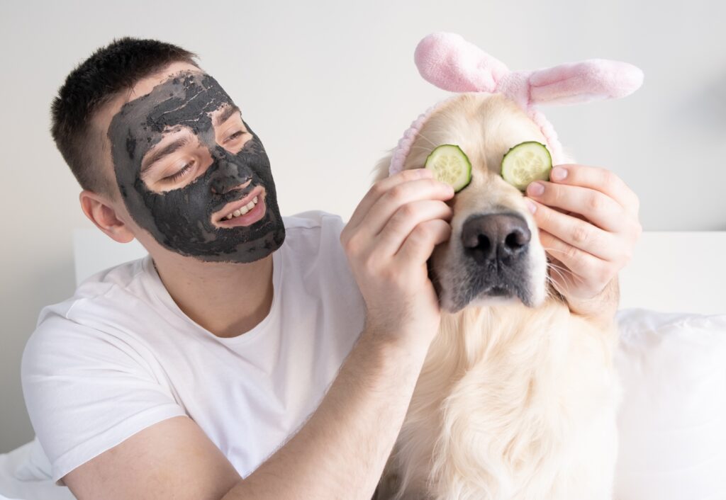 A man with a dog takes care of facial skin at home.